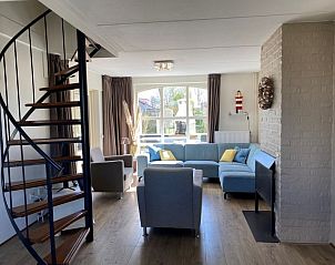 Gezellige woonkamer in Vakantiehuis E 417, De Cocksdorp, Texel met moderne inrichting en uitzicht op de groene omgeving.