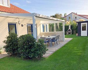 Ontspan op het terras van Vakantiehuis D 748 in De Cocksdorp, Texel. Geniet van de serene tuin en moderne buitenruimte op de Waddeneilanden.