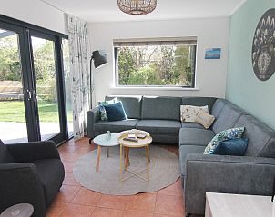Gezellige woonkamer van Vakantiehuis A 143 in De Cocksdorp, Texel. Comfortabele zitruimte met uitzicht op de groene omgeving.
