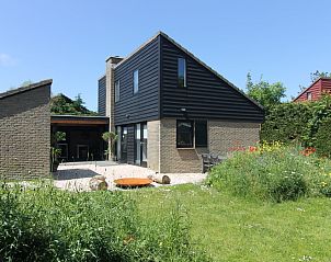 Vakantiehuis C 081 in De Cocksdorp, Texel, biedt een charmant terras met uitzicht op een weelderige tuin en moderne architectuur.
