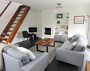 Gezellige woonkamer in Vakantiehuis A 351, De Cocksdorp, Texel met moderne inrichting en open haard voor een ontspannen verblijf op de Waddeneilanden.