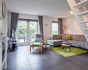 Gezellige woonkamer van Vakantiehuis A 141 in De Cocksdorp, Texel, met comfortabele zithoek en tuinzicht.