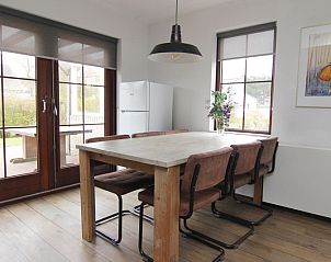 Gemtliche Essecke im Ferienhaus D 401 in De Cocksdorp, Texel, mit Holztisch und Blick auf den Garten der Watteninseln.