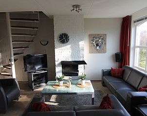 Gezellige woonkamer van Vakantiehuis D 720 in De Cocksdorp, Texel, met comfortabele banken en een sfeervolle open haard.