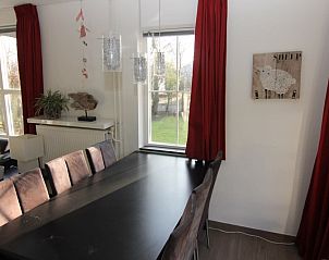 Gezellige eetkamer in Vakantiehuis D 720, De Cocksdorp, Texel met uitzicht op de tuin en stijlvolle inrichting.