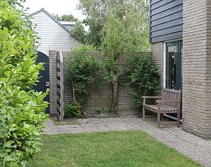 Rustig terras bij Vakantiehuis A 267 in De Cocksdorp, Texel, omringd door groen en perfect voor ontspanning op de Waddeneilanden.