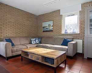 Gezellige woonkamer van Vakantiehuis A 267 in De Cocksdorp, Texel, met comfortabele zitbank en warme sfeer.