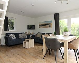 Gezellige woonkamer in Vakantiehuis A 287 in De Cocksdorp, Texel. Comfortabele zithoek en eetruimte met uitzicht op de groene omgeving.