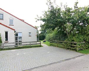 Vakantiehuis D 533 in De Cocksdorp, Texel, biedt een rustige omgeving met groene natuur en een uitnodigend terras voor ontspanning.