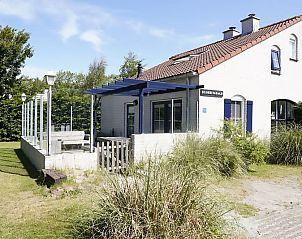 Vakantiehuis D 696 in De Cocksdorp, Texel met zonnige veranda en groene omgeving, ideaal voor een ontspannen verblijf op de Waddeneilanden.