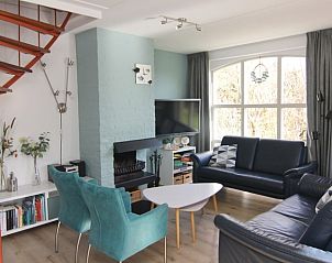 Gezellige woonkamer van Vakantiehuis D 601 in De Cocksdorp, Texel, met comfortabele banken en een sfeervolle open haard.