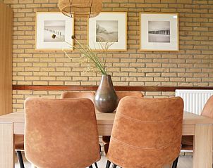 Gezellige eetkamer van Vakantiehuis B 031 in De Cocksdorp, Texel, met stijlvolle inrichting en kunst aan de muur voor een ontspannen verblijf.