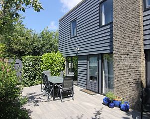 Ontspan op het zonnige terras van Vakantiehuis A 359 in De Cocksdorp, Texel. Geniet van de serene omgeving op de Waddeneilanden.