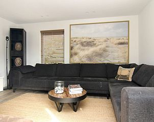 Gezellige woonkamer van Vakantiehuis A 075 in De Cocksdorp, Texel, met comfortabele zithoek en natuurdecor voor een ontspannen verblijf.