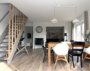 Moderne eetkamer in Vakantiehuis A 075, De Cocksdorp, Texel. Ruime binnenruimte met houten vloer en stijlvolle inrichting, ideaal voor ontspanning.