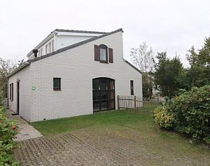 Vakantiehuis E 655 in De Cocksdorp, Texel biedt een charmante buitenaanzicht met groene omgeving en rustige sfeer op de Waddeneilanden.