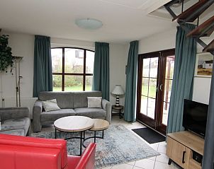 Gezellige woonkamer in Vakantiehuis E 655, De Cocksdorp, Texel. Comfortabele zithoek met uitzicht op de groene tuin van de Waddeneilanden.