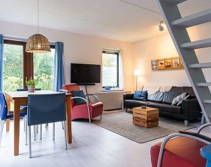 Gezellige woonkamer van Vakantiehuis B 043 in De Cocksdorp, Texel, met moderne meubels en uitzicht op groene natuur.
