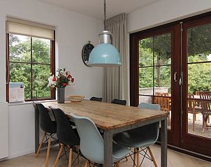 Gezellige eetruimte in Vakantiehuis D 475, De Cocksdorp, Texel met uitzicht op terras en groene omgeving.