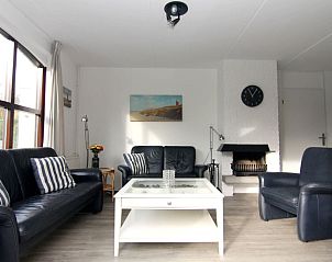 Gezellige woonkamer in Vakantiehuis F 575, De Cocksdorp, Texel, met comfortabele zithoek en open haard voor een ontspannen verblijf.