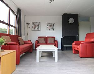 Gezellige woonkamer in Vakantiehuis E 407, De Cocksdorp, Texel, met comfortabele rode banken en moderne inrichting.