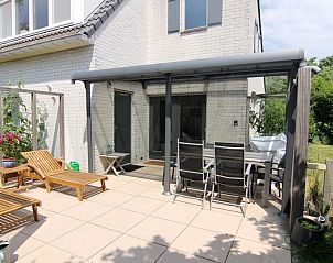 Geniet van het zonnige terras bij Vakantiehuis F 654 in De Cocksdorp, Texel, met comfortabele ligstoelen en een overdekte eetruimte.