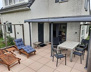 Vakantiehuis F 654 in De Cocksdorp, Texel biedt een uitnodigend terras met comfortabele ligstoelen en een eettafel voor ontspanning in de buitenlucht.