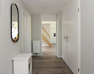 Heldere gang in Vakantiehuis F 775, De Cocksdorp, Texel. Moderne inrichting met houten vloer en toegang tot de keuken.