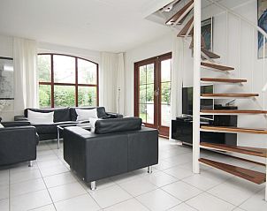 Moderne woonkamer van Vakantiehuis E 638 in De Cocksdorp, Texel, met stijlvolle inrichting en uitzicht op de groene omgeving.