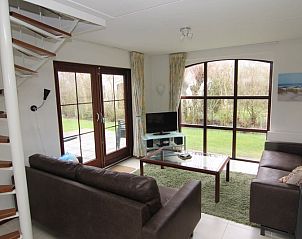Gezellige woonkamer van Vakantiehuis E 571 in De Cocksdorp, Texel, met uitzicht op de tuin en comfortabele zithoek.