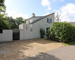 Vakantiehuis F 782 in De Cocksdorp, Texel, biedt een charmante buitenaanblik met een uitnodigende oprit en groene omgeving.