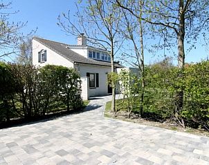 Vakantiehuis F 604 in De Cocksdorp, Texel biedt een serene buitenomgeving met een uitnodigend terras omringd door groen.
