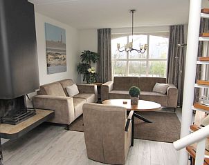 Gezellige woonkamer van Vakantiehuis F 604 in De Cocksdorp, Texel met comfortabele zitruimte en uitzicht op de groene omgeving.