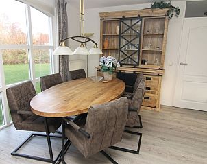 Gezellige eetkamer in Vakantiehuis F 604, De Cocksdorp, Texel, met houten tafel en ruime stoelen, ideaal voor familiebijeenkomsten.