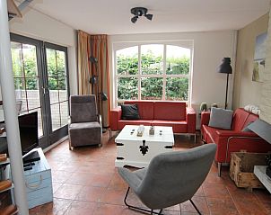 Gezellige woonkamer van Vakantiehuis E 646 in De Cocksdorp, Texel, met comfortabele zitruimte en uitzicht op de groene tuin.