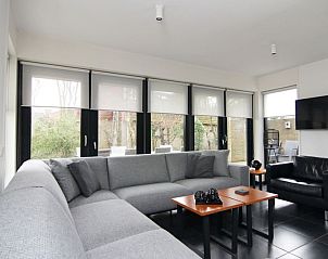 Gezellige woonkamer van Vakantiehuis G 049 in De Cocksdorp, Texel, met comfortabele zitruimte en uitzicht op de groene omgeving.