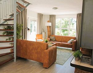 Cozy living room of Holiday home F 681 in De Cocksdorp, Texel with comfortable seating area and large windows for a beautiful view.