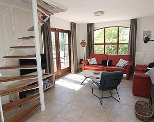 Gezellige woonkamer van Vakantiehuis E 413 in De Cocksdorp, Texel, met ruime zithoek en uitzicht op de groene omgeving.