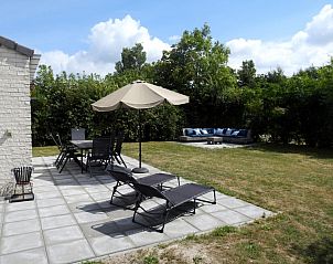 Geniet van het terras van Vakantiehuis E 614 in De Cocksdorp, Texel met comfortabele ligstoelen en een uitnodigende tuinomgeving.