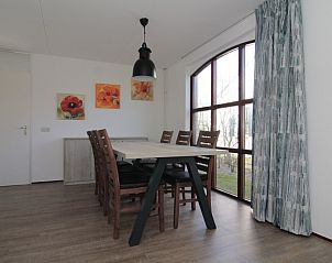 Eetkamer van Vakantiehuis E 660 in De Cocksdorp, Texel met grote ramen en moderne inrichting, ideaal voor een ontspannen vakantie op de Waddeneilanden.