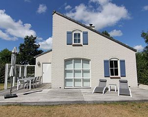Vakantiehuis E 634 in De Cocksdorp, Texel biedt een zonnig terras met comfortabele ligstoelen en een schilderachtig uitzicht op de natuur.