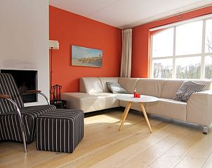 Gezellige woonkamer van Vakantiehuis E 634 in De Cocksdorp, Texel met comfortabele zithoek en grote ramen voor veel natuurlijk licht.