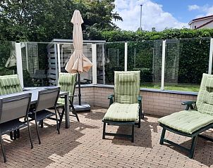 Geniet van het zonnige terras bij Vakantiehuis E 409 in De Cocksdorp, Texel, met comfortabele ligstoelen en een ruime eettafel.