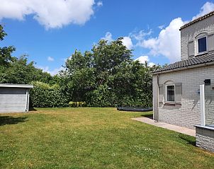Ruime tuin van Vakantiehuis E 409 in De Cocksdorp, Texel, omgeven door groene natuur voor een ontspannen verblijf op de Waddeneilanden.