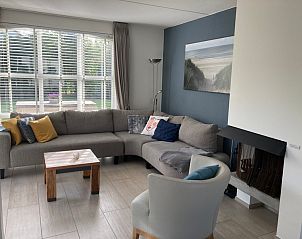Gezellige woonkamer van Vakantiehuis E 501 in De Cocksdorp, Texel, met comfortabele zithoek en uitzicht op de groene omgeving.