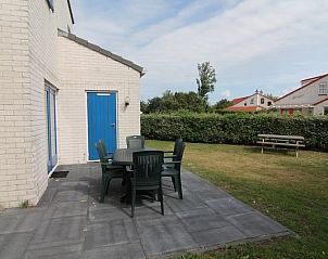 Geniet van het terras van Vakantiehuis E 421 in De Cocksdorp, Texel, omgeven door groene natuur en rust van de Waddeneilanden.