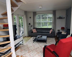 Cozy living room in Holiday home E 511, De Cocksdorp, Texel, with comfortable seating area and views of the green surroundings.