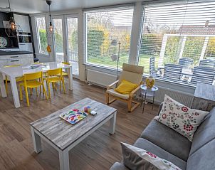 Gezellige woonkamer van Vakantiehuis Slufterhoek 080 in De Cocksdorp, Texel met uitzicht op de tuin en veel natuurlijk licht.