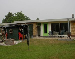 Bungalow Tamarisk 210 in De Cocksdorp, Texel met een uitnodigend terras en groene omgeving, ideaal voor een ontspannen vakantie op de Waddeneilanden.
