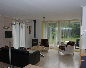 Gezellige woonkamer in Bungalow Tamarisk 210, De Cocksdorp, Texel met tuinzicht en comfortabele zithoek.